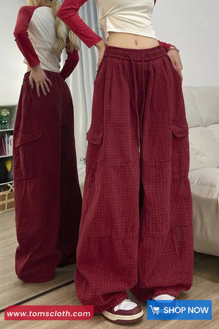 Two people wearing maroon wide-leg pants with pockets in a room.