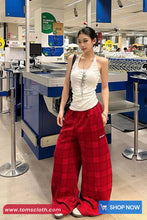 Woman wearing a white top and red plaid pants in a store setting with promotional text at the bottom.