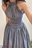 Woman wearing a gray and white striped dress against a neutral background