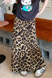 Person wearing a leopard print skirt and black t-shirt with a graphic design, standing in a casual setting.