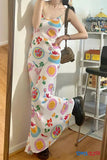 Person wearing a colorful dress with fruit patterns in a room.