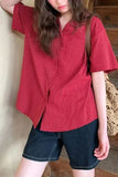 Person wearing a red striped shirt and denim shorts, holding a straw bag indoors.