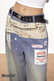 Studded and embellished jeans with visible branding on a plain background