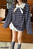Person wearing a striped shirt with a white collar in an indoor setting