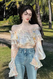 Woman wearing a floral off-shoulder top and jeans in a tropical setting