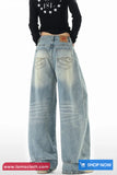 Wide-leg jeans worn by a person on a white background with 'tomscloth.com' branding.
