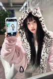 Person wearing a leopard print hoodie and pink jacket holding a phone with a mirror reflection.