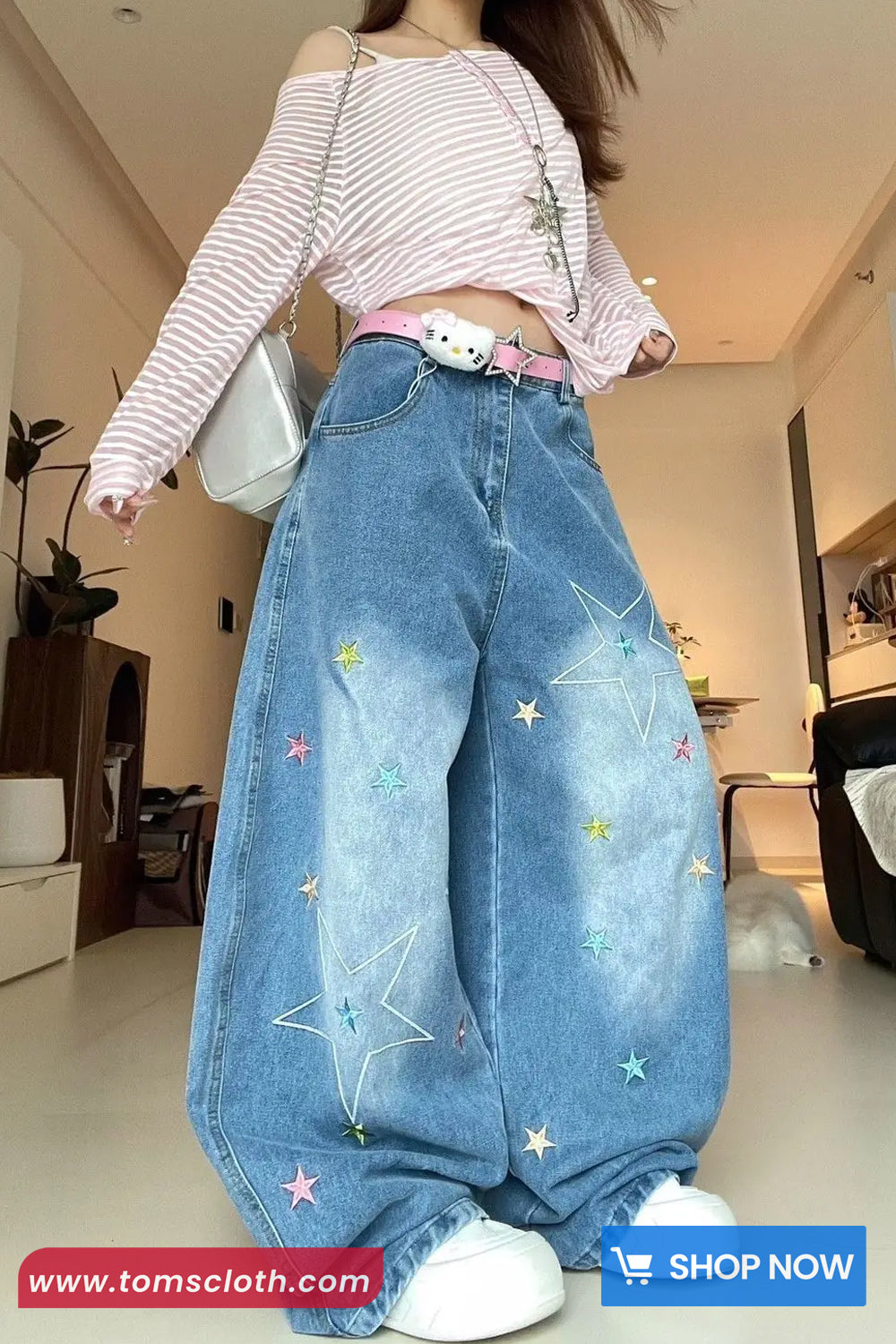 Person wearing blue jeans with star patterns in a room.