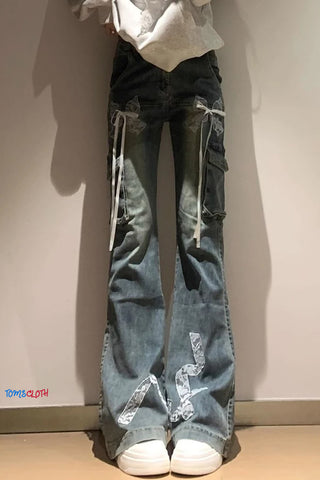 Person wearing blue jeans with white drawstrings and reflective accents against a plain background.