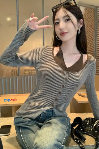 Woman posing in a casual setting with a striped sweater and jeans