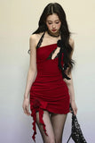Woman wearing a red dress with black accents against a plain background