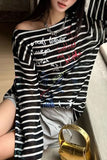 Person wearing a black and white striped shirt with colorful text, sitting on a couch.
