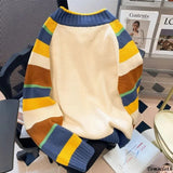 Colorful striped sweater on a chair with a magazine in the background
