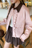 Person wearing a pink jacket with a brown collar in an indoor setting