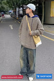 Person wearing a striped sweater and jeans walking on a street, with 'www.tomscloth.com' and 'SHOP NOW' text at the bottom.