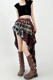 Person wearing a black crop top, plaid skirt, and brown knee-high boots on a white background