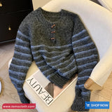 Striped sweater on a chair with a visible brand tag and website URL.