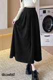 Person wearing a black skirt in a room with a washing machine.