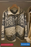 Knitted sweater with black and white pattern on a hanger, brand 'TomsCloth' visible.