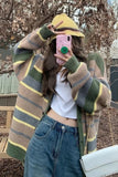 Person wearing a plaid cardigan, white shirt, and blue jeans outdoors.