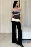 Woman wearing a gradient top and black pants with a white lace trim, standing against a neutral curtain background.