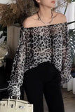 Person wearing a leopard print off-shoulder top and black pants in an indoor setting.