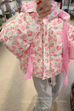 Person wearing a floral pink jacket indoors