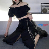 Person wearing a black outfit with a choker, sitting on the floor with a boombox in the background.