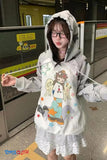 Person wearing a hoodie with cartoon design in an indoor setting