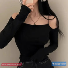 Person wearing a black long-sleeve top with a plain background