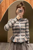 Person wearing a striped jacket taking a mirror selfie.