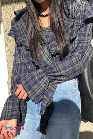 Person wearing a plaid shirt with a brand logo in the corner
