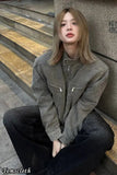 Person wearing a green jacket sitting on steps with 'Tomscloth' branding.