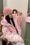 Person wearing a floral patterned jacket and pink hat sitting on a chair.