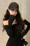 Woman wearing a black cap and black outfit against a neutral background