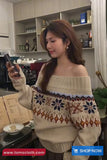 Woman wearing a patterned sweater in a kitchen setting