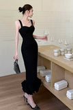 Woman in a black dress holding a glass in a modern interior setting