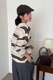 Woman wearing a patterned sweater and leopard print cap indoors.