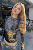 Person wearing a leopard print top with a plaid shirt underneath, standing in an urban setting.
