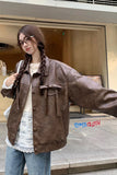 Person wearing a brown leather jacket in an urban setting