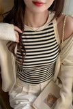 Person wearing a black and white striped top with a beige cardigan.
