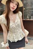 Woman wearing a floral blouse and straw hat outdoors