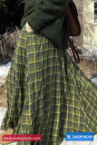 Green plaid fabric with a person wearing a dark green coat in an outdoor setting.