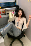 Woman sitting in an office chair with a desk and computer in the background