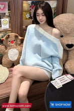 Woman wrapped in a blanket sitting among teddy bears with a 'Shop Now' button visible.