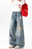 Person wearing blue jeans with star patterns, holding a red bag on a white background