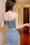 Woman wearing a denim dress in a room with wooden flooring.