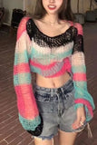 Person wearing a colorful knitted sweater and denim shorts indoors.