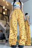 Person wearing a colorful top and yellow patterned pants in an indoor setting.