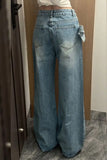 Blue jeans worn by a person standing in a room with wooden walls and a marble floor.